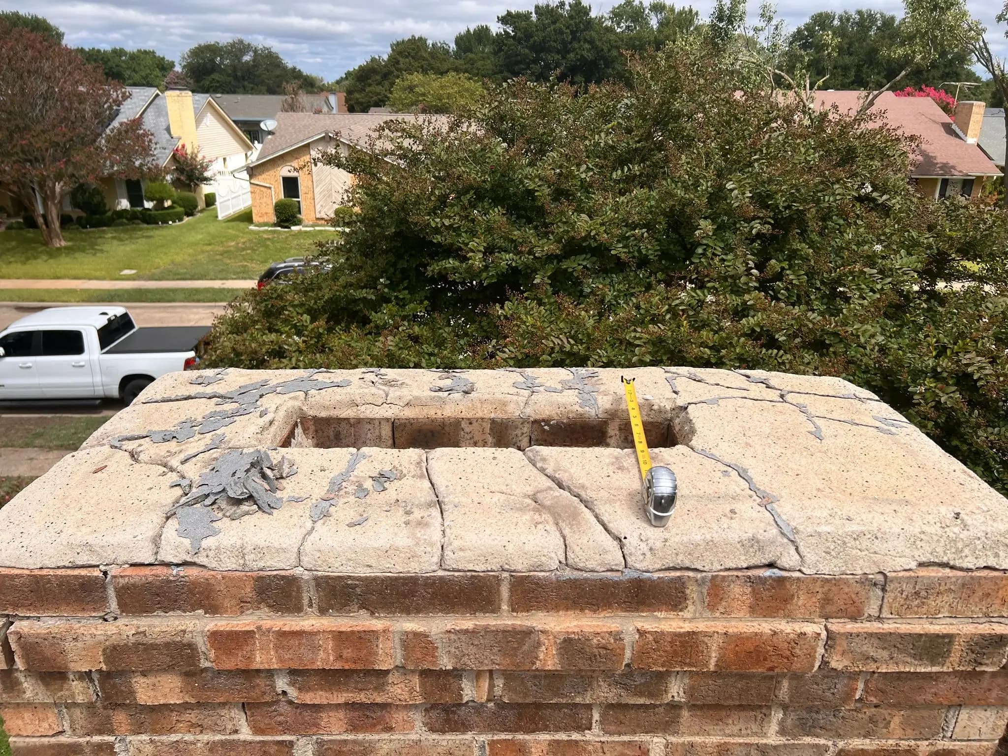 Damaged chimney crown assessed before repair